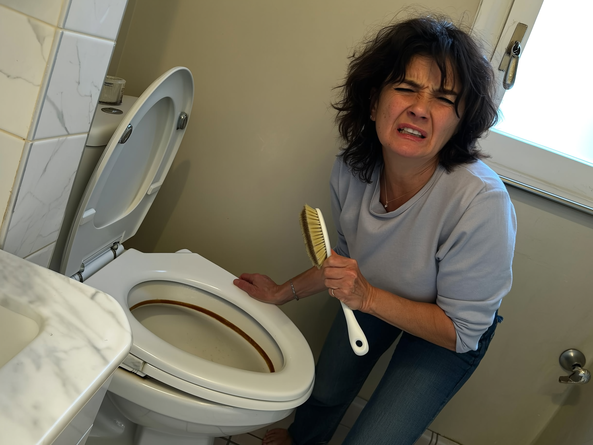 Frustrated woman scrubbing toilet